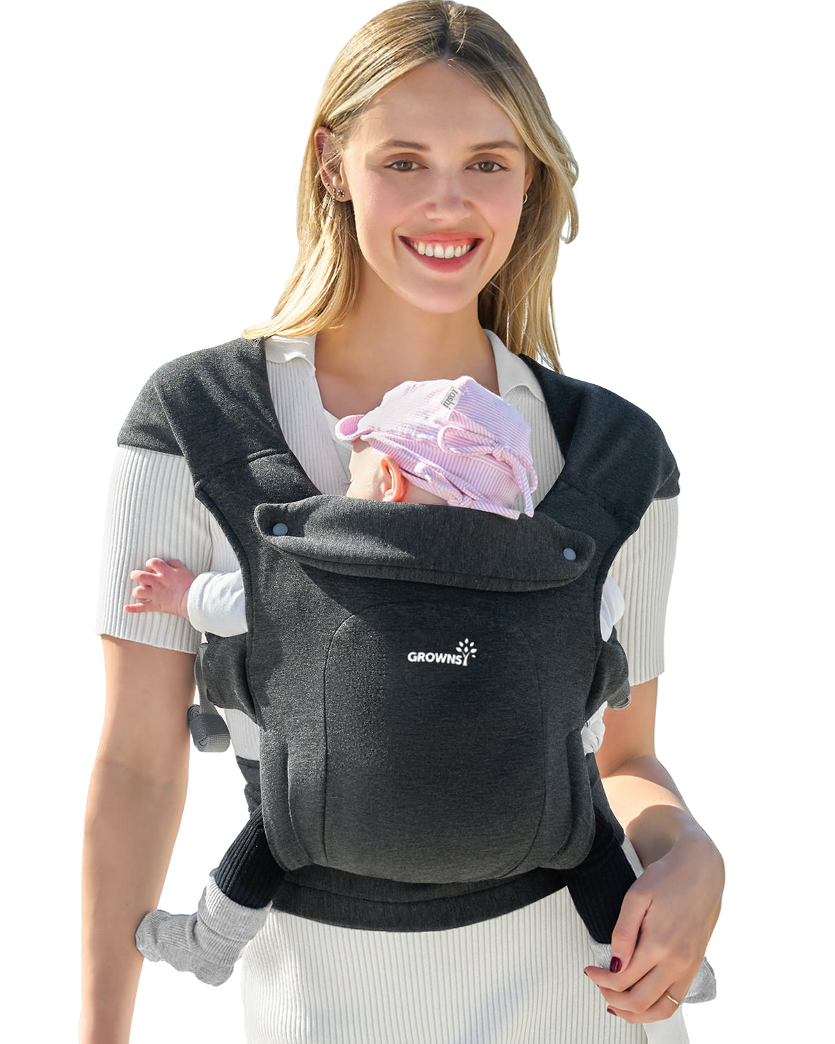 Woman smiling, carrying baby in a dark gray Grownsy ergonomic soft-fabric baby carrier with pink striped hat.