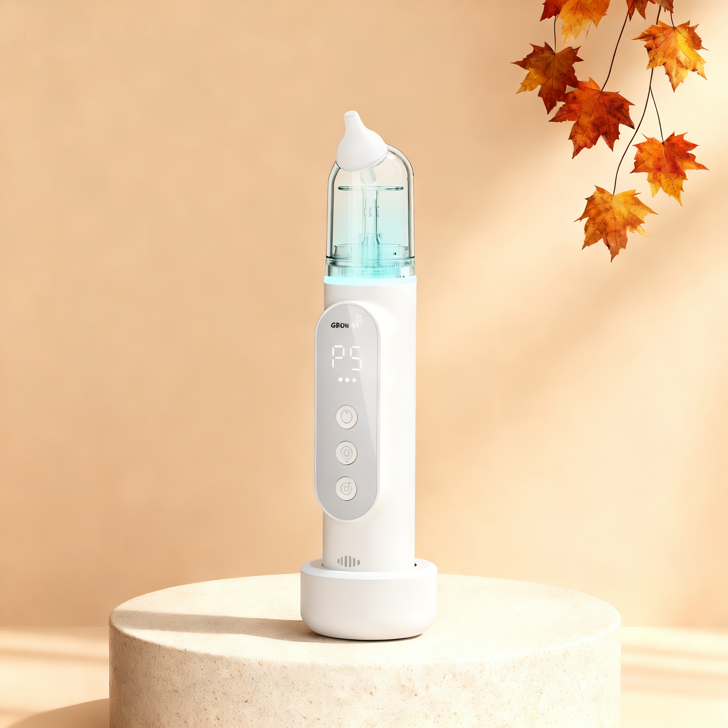 White electric baby nasal aspirator with blue chamber and digital display, on pedestal with autumn leaves backdrop.