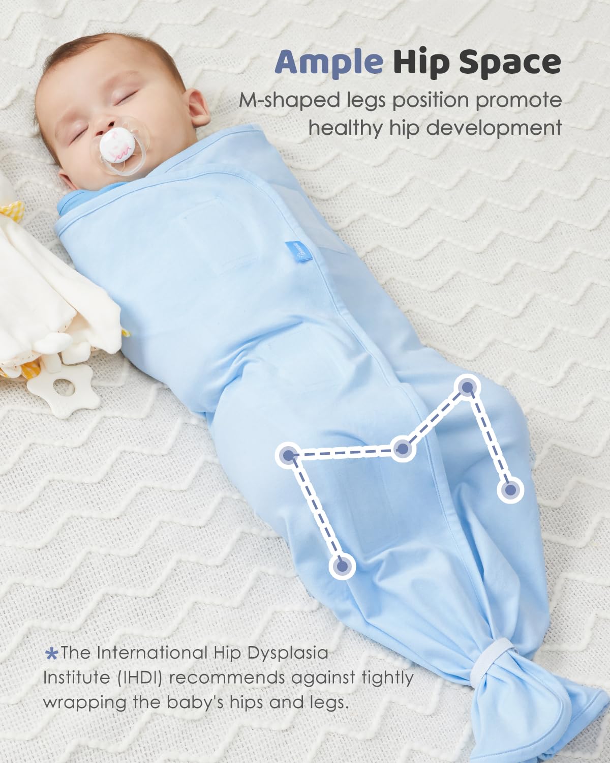 Baby in pink cotton swaddle sack with ample hip space for healthy hip development, M-shaped leg position.