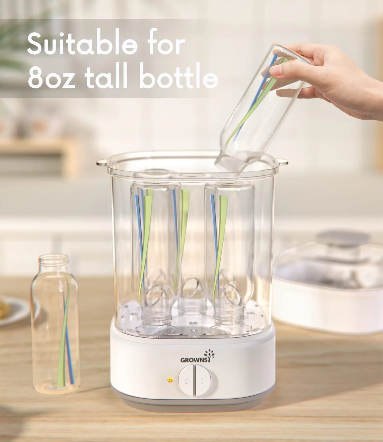 Grownsy electric bottle sterilizer showing capacity for tall 8oz baby bottles, white base with dial on wooden counter.