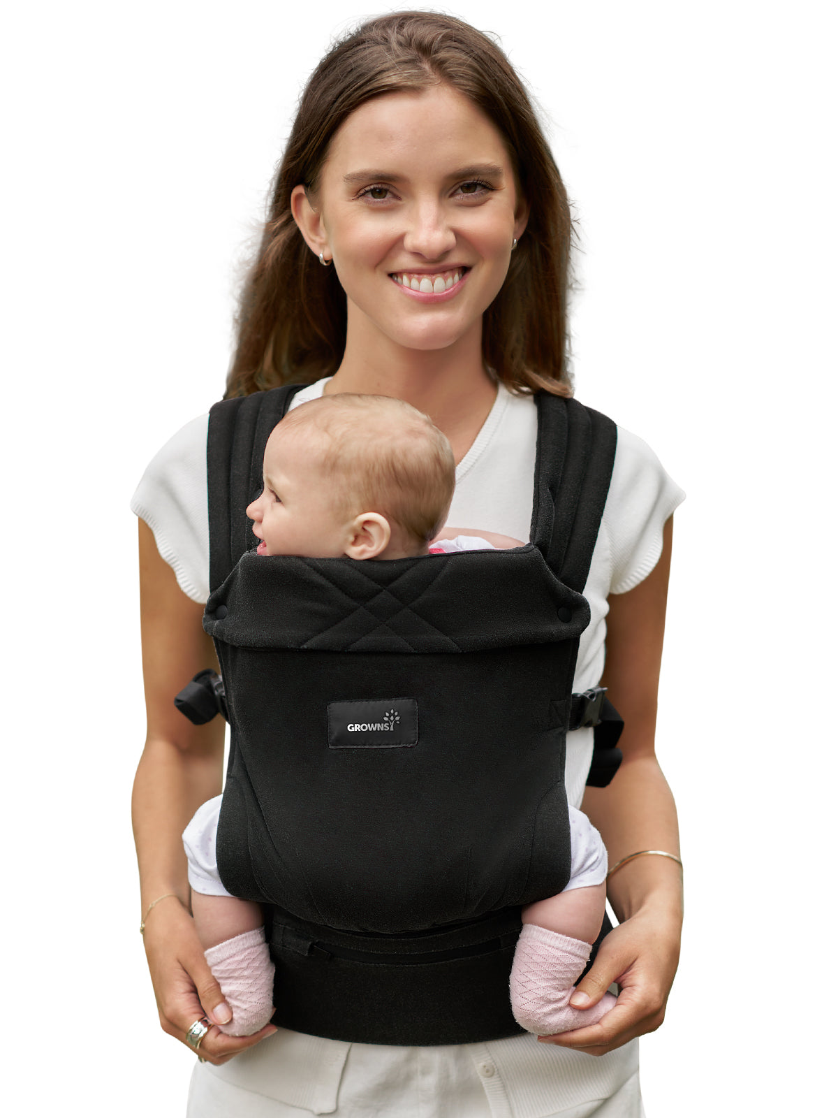 Woman smiling, wearing a black baby carrier with a baby inside. Ideal for the Newborn Welcome Bundle page.