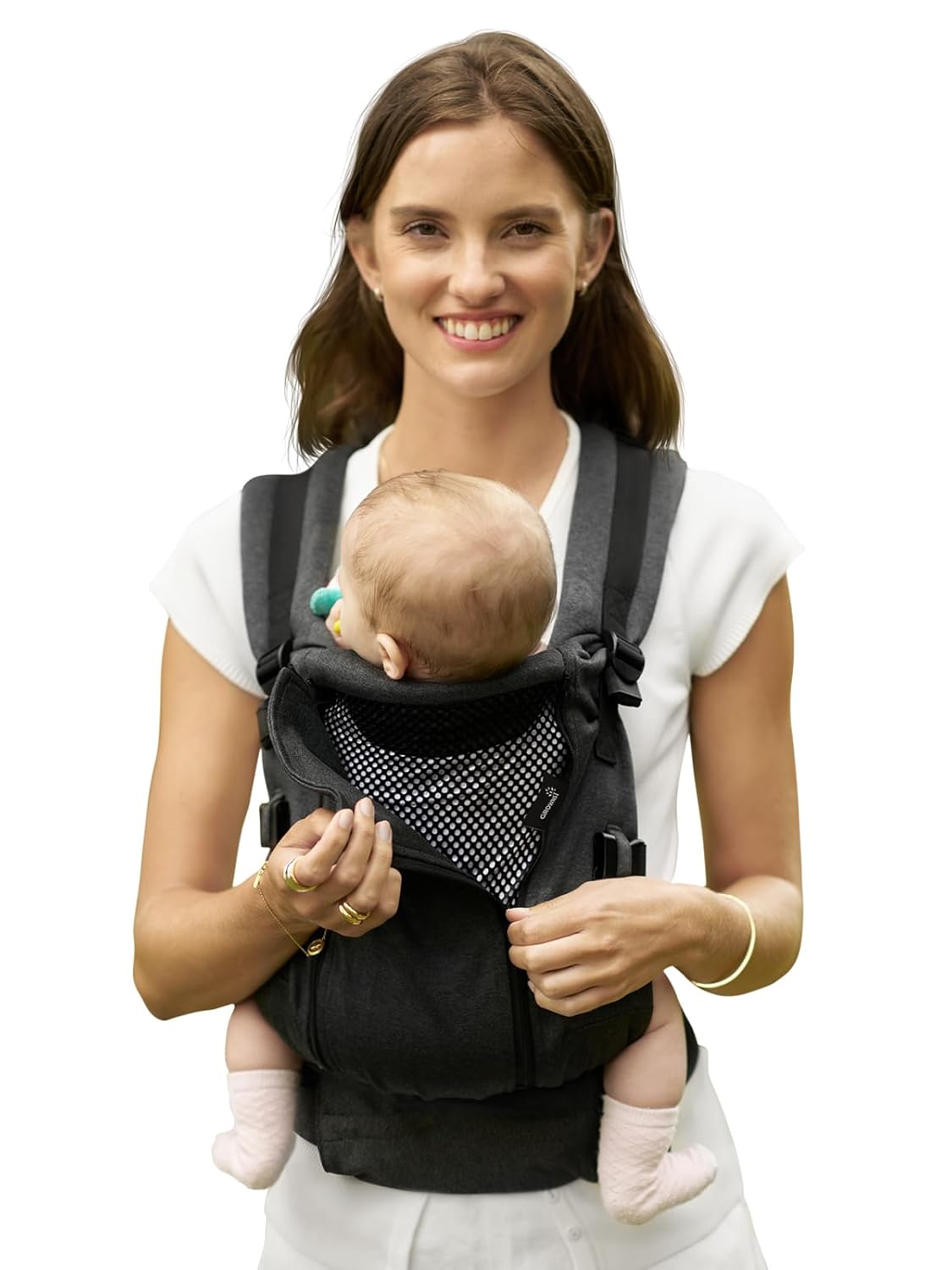 Woman smiles wearing dark gray ergonomic baby carrier with mesh interior, holding baby with pacifier, product showcase.