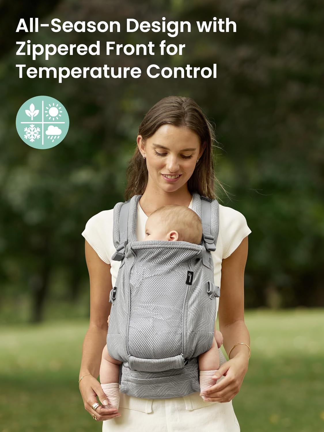 Woman wearing a gray patterned ergonomic baby carrier with visible zippered mesh panel and 'All-Season Design' text.
