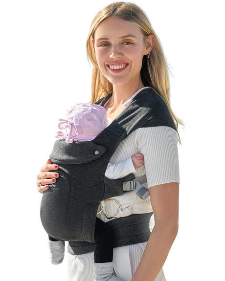 Charcoal grey ergonomic baby carrier with head support on smiling mom holding newborn baby.