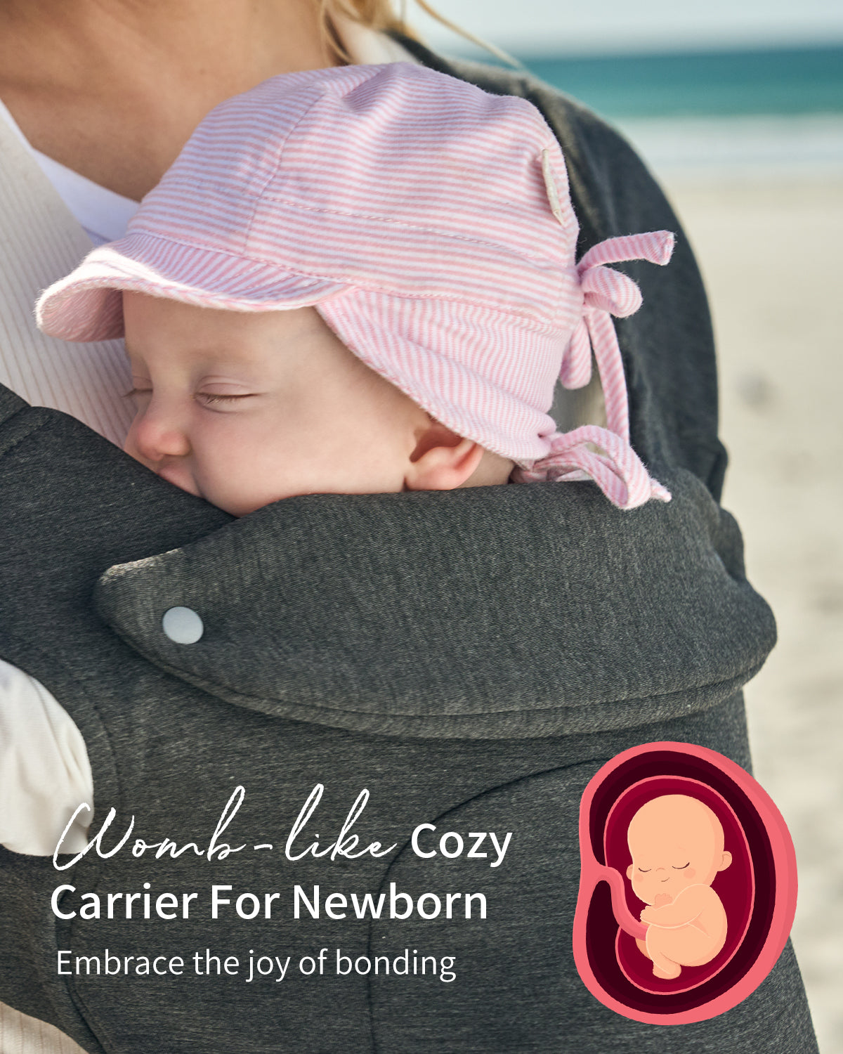 Dark grey ergonomic baby carrier, womb-like cozy fit for sleeping newborn with pink bonnet. Newborn carrier page.