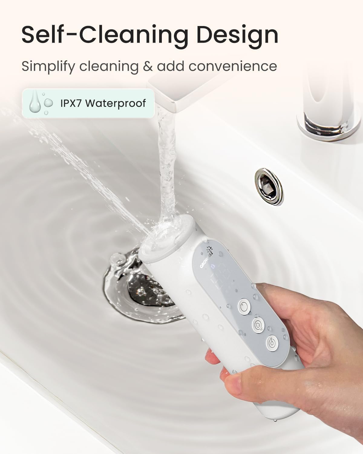 White electric baby nasal aspirator being rinsed; IPX7 waterproof and self-cleaning feature demonstration.