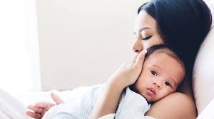 Mother gently holding and soothing her newborn baby on her chest