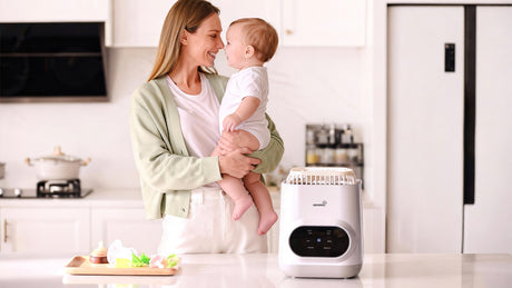 Mother holding baby in kitchen near GROWNSY baby bottle sterilizer and feeding accessories