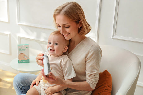 A mother gently uses a nasal aspirator on her baby, providing relief during cold season.